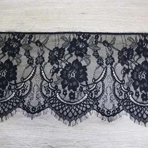 Detailansicht der schwarzen Spitzenborte mit zarten Wimpernfransen für elegante Bekleidung.