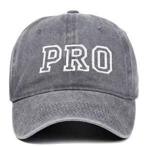 Vista detallada de una gorra de béisbol de algodón lavado gris con bordado PRO blanco