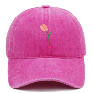 Gros plan sur une casquette de baseball rose délavée avec broderie de tulipe délicate
