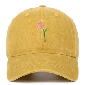Détail macro de broderie tulipe rose sur une casquette en coton lavé jaune de style vintage