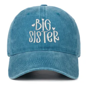 Gedetailleerde macro-opname van Big Sister borduursel op gewassen blauwe baseballpet