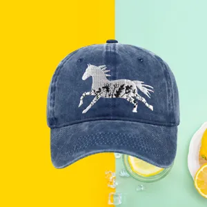 Detailed view of the white horse floral embroidery on a blue washed cotton baseball cap.