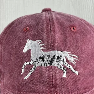 Close-up of floral horse embroidery on washed cotton baseball cap