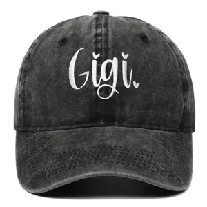 Primo piano del ricamo bianco 'Gigi' su un cappellino da baseball grigio lavato.