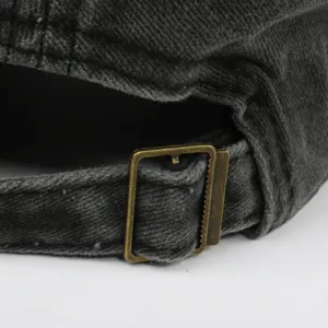 Detail of the adjustable metal buckle on a washed distressed cotton baseball cap