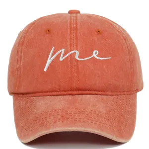 Front view of an orange washed cotton baseball cap with white 'me' embroidery.