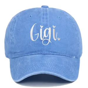 Dettaglio del ricamo bianco 'Gigi' su un cappellino da baseball in denim lavato blu