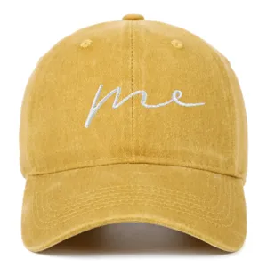 Detailed view of a yellow washed cotton baseball cap with white 'me' embroidery
