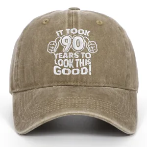 Close-up of white embroidered 90th birthday slogan on brown washed cotton baseball cap
