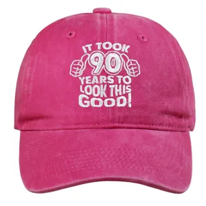 Close-up of pink washed cotton baseball cap featuring white 90th birthday embroidery