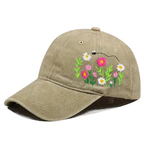 Detailansicht der bunten Blumenstickerei auf einer beige gewaschenen Baumwollkappe.