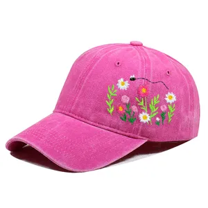 Nahaufnahme einer leuchtend pinkfarbenen Baseballkappe mit feiner Blumenstickerei für Damen