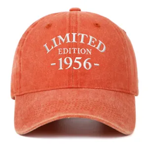 Detailed view of white '1956' embroidery on orange washed cotton baseball cap