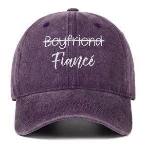Detailed close-up of white Fiancé embroidery on purple washed cotton baseball cap