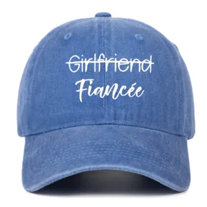 Close-up detail of blue washed denim baseball cap featuring white 'Fiancée' embroidery