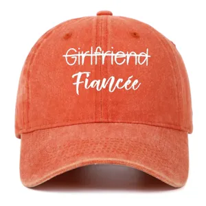 Close-up of vintage washed orange baseball cap with white Fiancée embroidery.