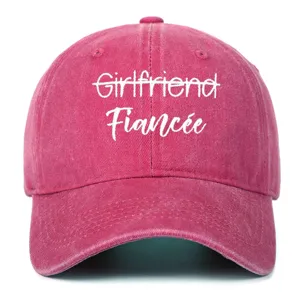Detail view of rose-red washed cotton baseball cap with white Fiancée embroidery detail.
