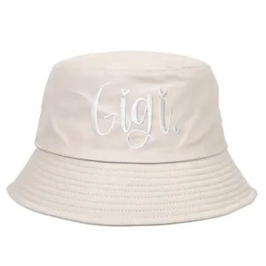 Detail view of a vintage beige cotton bucket hat featuring white Gigi letter embroidery