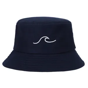 Detail view of a navy blue bucket hat featuring a white wave embroidery pattern