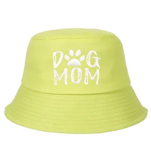 Vista detallada del bordado 'DOG MOM' en este sombrero de pescador de algodón verde.