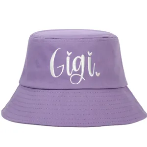 Detailed white 'Gigi' script embroidery on a soft purple cotton bucket hat accessory.