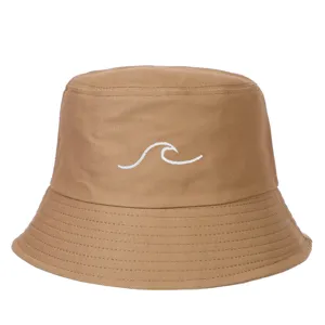 Detailed close-up showing the white wave embroidery on a brown canvas bucket hat