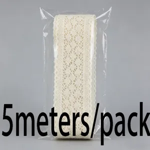 Detailopname van beige katoenen kantband rol verpakt in een transparante zak, 5 meter lang.