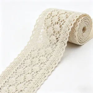Detailopname van beige katoenen gehaakte kantrand, met fijne holle bloemmotief textuur.