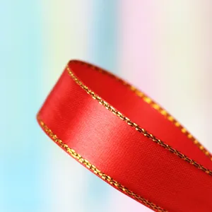 Close-up detail of red ribbon with metallic edge stitching, perfect for gift wrapping and decor.