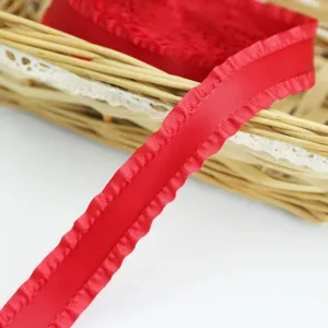 Red pleated ribbon close-up, perfect detail view of ruffled satin fabric for gift wrapping.