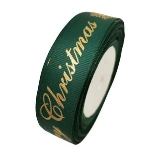 Nastro in grosgrain verde scuro con scritta di Natale dorata e fiocchi, dettaglio.