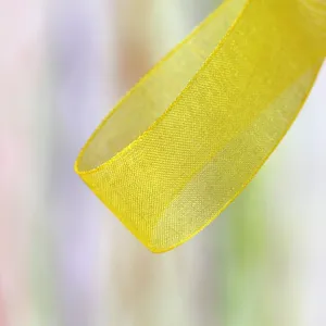 Yellow sheer organza ribbon close up detail, perfect for gift box packaging, floral bows and crafts.