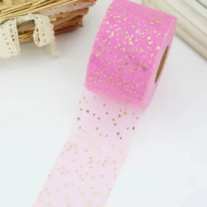 Rosa Tüllrolle mit goldenen Sternen für Geschenkverpackung, Blumen und Bastelarbeiten.