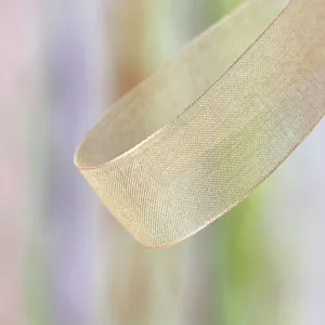 Close up detail view of golden sheer organza ribbon, perfect for gift wrapping and flower bows.