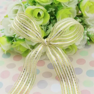 Primo piano del bellissimo fiocco in nastro lucido a righe bianco e oro da 15mm per regali