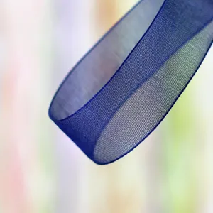 Detail shot of deep blue sheer organza ribbon, showing fine woven texture for gift wrapping and crafts.