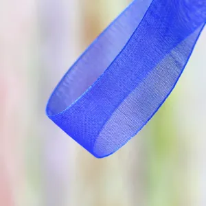 Blue sheer organza ribbon close up, delicate fabric texture detail for gift wrapping.
