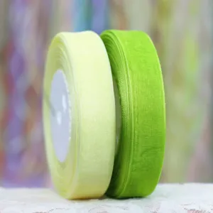 Close-up detail of sheer organza ribbon rolls in soft yellow and vibrant green colors.