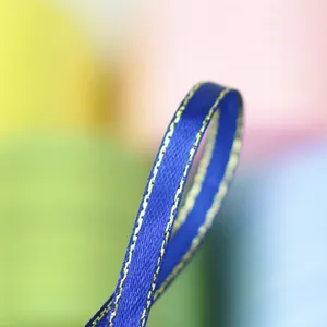 Blue ribbon with gold edge 6mm wide, detailed closeup view of gift wrapping silk ribbon.