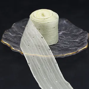 Detailansicht einer 4cm Strass-Netzbandrolle auf Glasteller, ideal zum Verpacken von Geschenken.
