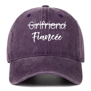 Front view of a purple washed cotton baseball cap featuring white Fiancee embroidery