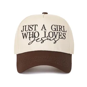 Gros plan sur la broderie JUST A GIRL WHO LOVES JESUS sur une casquette de camionneur bicolore.