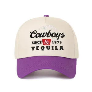 Detailed view of Cowboys and Tequila embroidery on a purple and beige trucker hat.