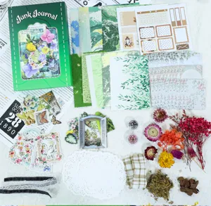 Retro junk journal materiaalkit met groene achtergrondpapier, stickers en gedroogde bloemen.