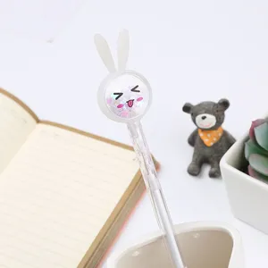 Cute cartoon rabbit gel pen with sparkly sequins and emoji face on a desk setup
