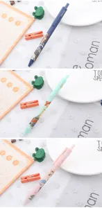 Detailed view of three pastel Koi fish pattern retractable gel pens with student stationery props