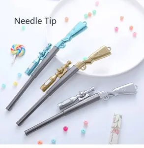 Gros plan de stylos gel créatifs en forme de fusil de précision en bleu, or et argent