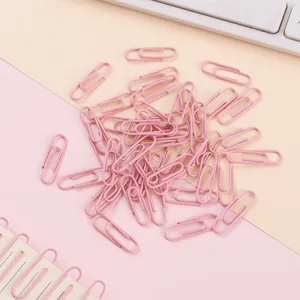 Detailopname van roze gecoate metalen paperclips, ideaal voor kantoorartikelen en boekenleggers.