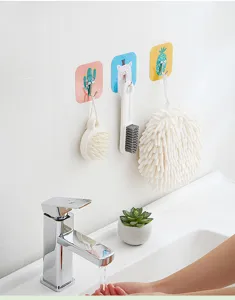 Strong cartoon adhesive wall hooks shown in a bathroom setting holding brushes and a loofah
