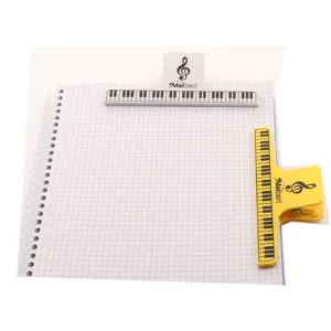 Detail shot of creative piano keyboard music clips in white and yellow, holding grid paper.